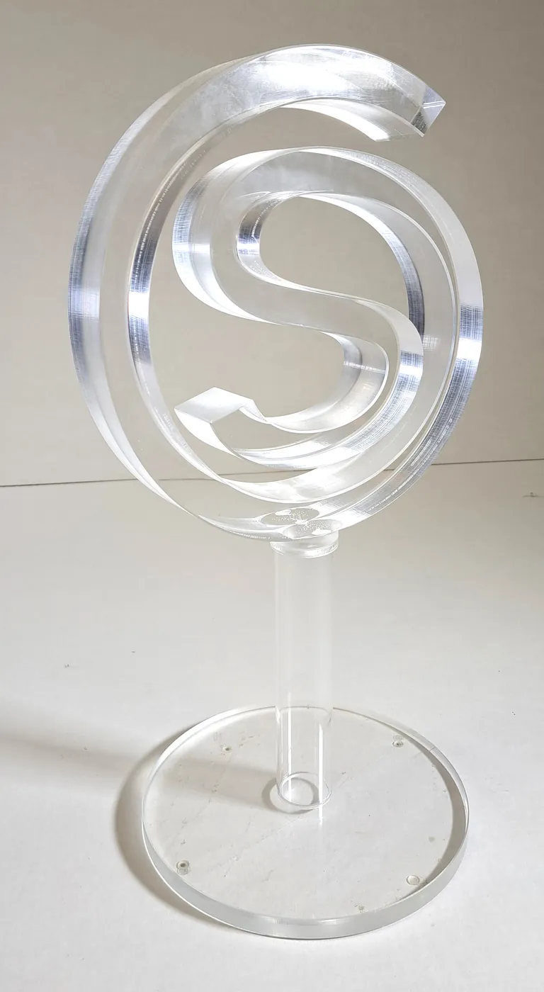 Clear acrylic letter S inside a ring, standing on a rod over a round clear base