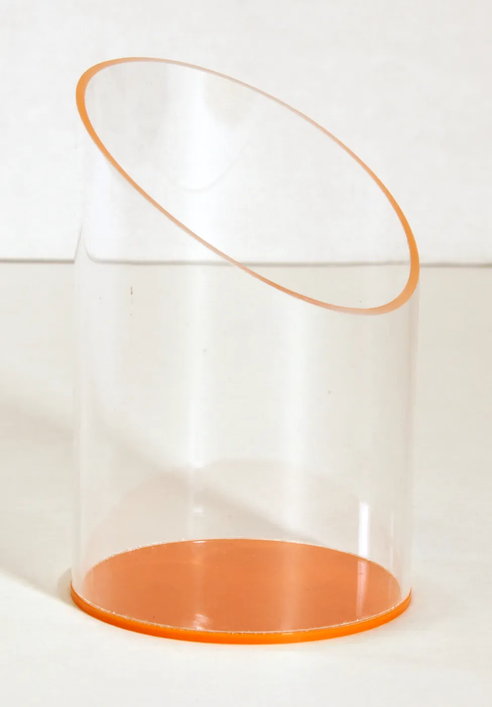 Clear acrylic tube with an angled top, standing on an orange base