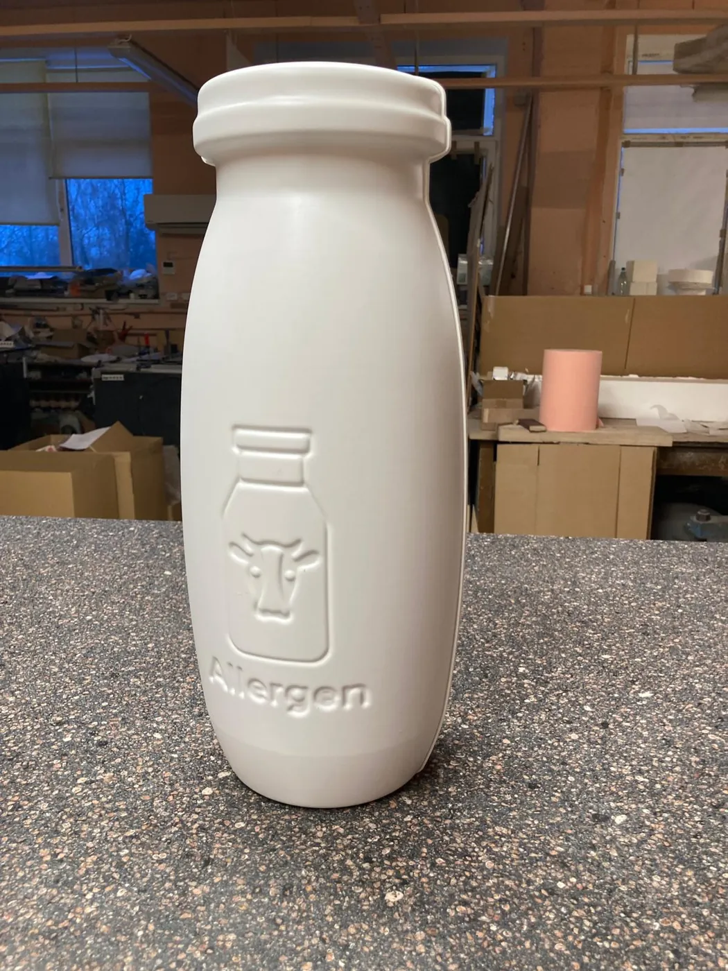 The other side of the bottle model, with an embossed bottle-and-cow motif
