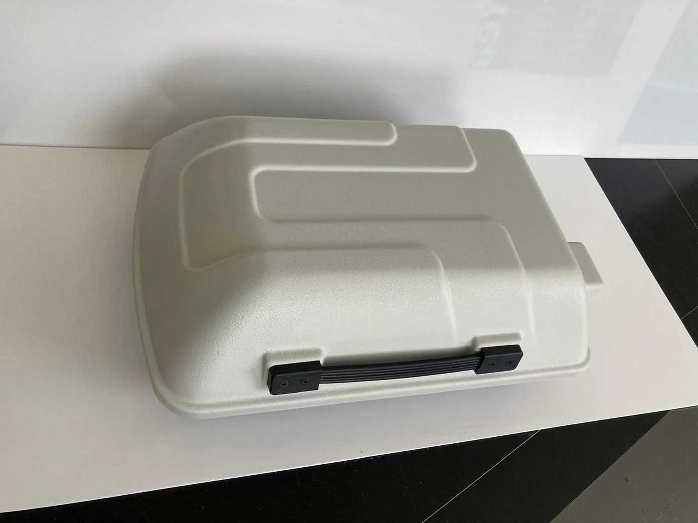 Top of the same enclosure seen from above, with a raised pattern and a black carry handle