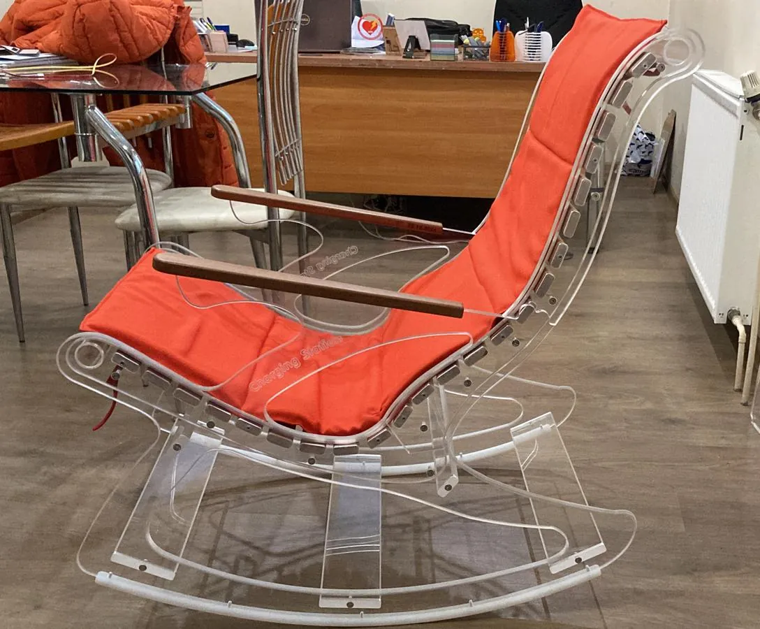 Rocking chair with a clear acrylic frame, an orange cushion and wooden armrests, seen from the side