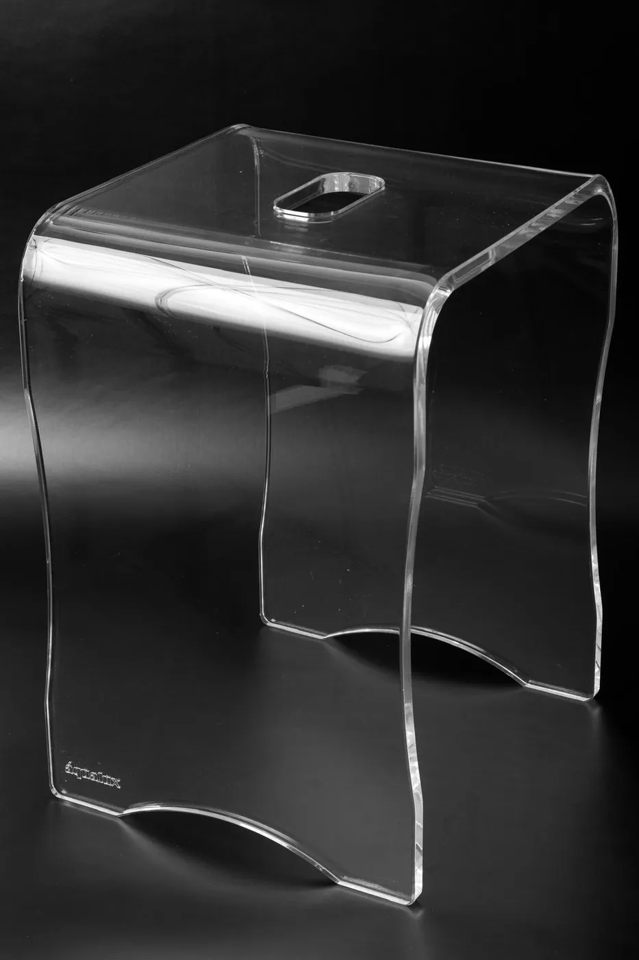 Clear acrylic stool made from one curved sheet, with a hand slot in the seat