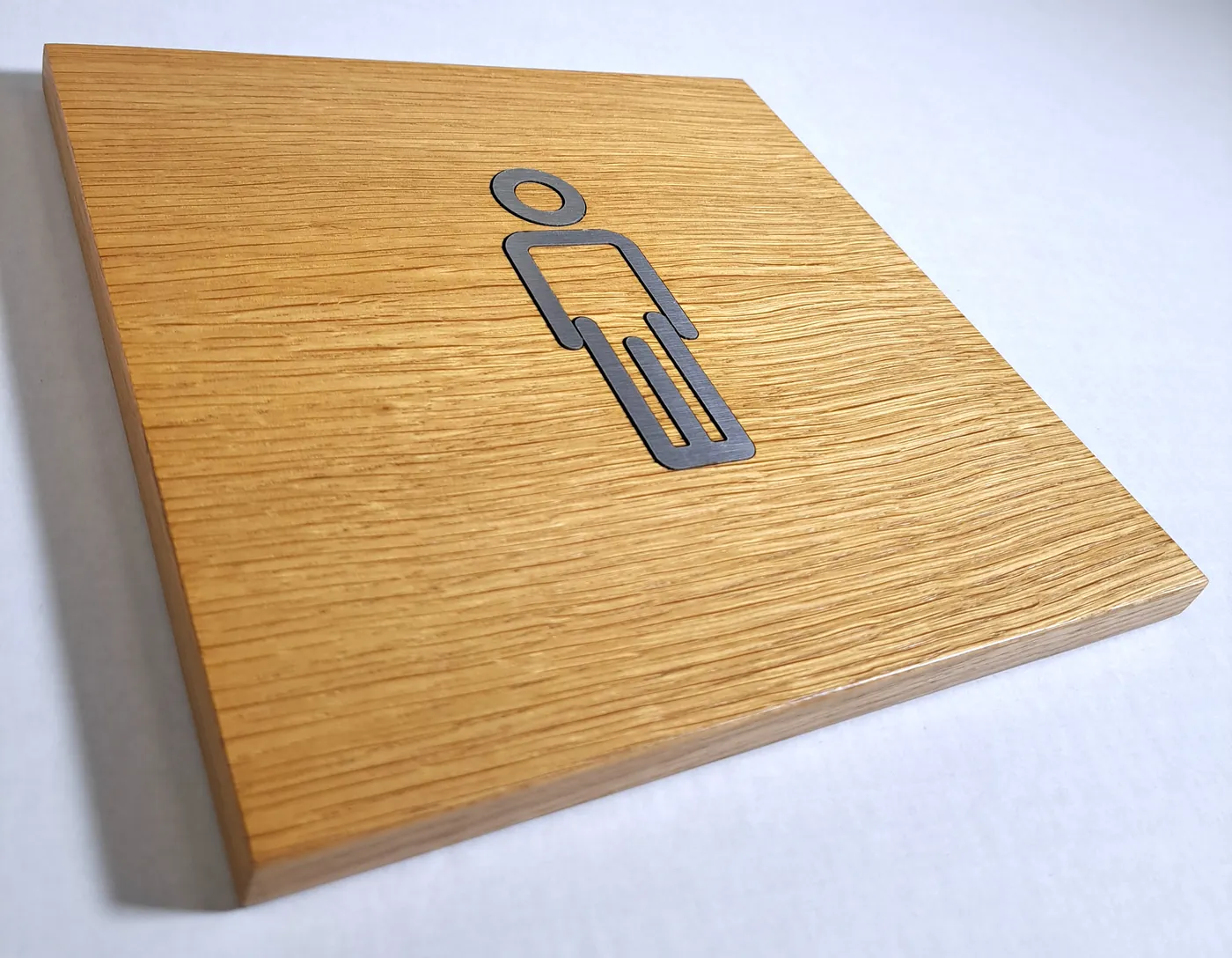 Oak door plate with a grey man pictogram set into the surface