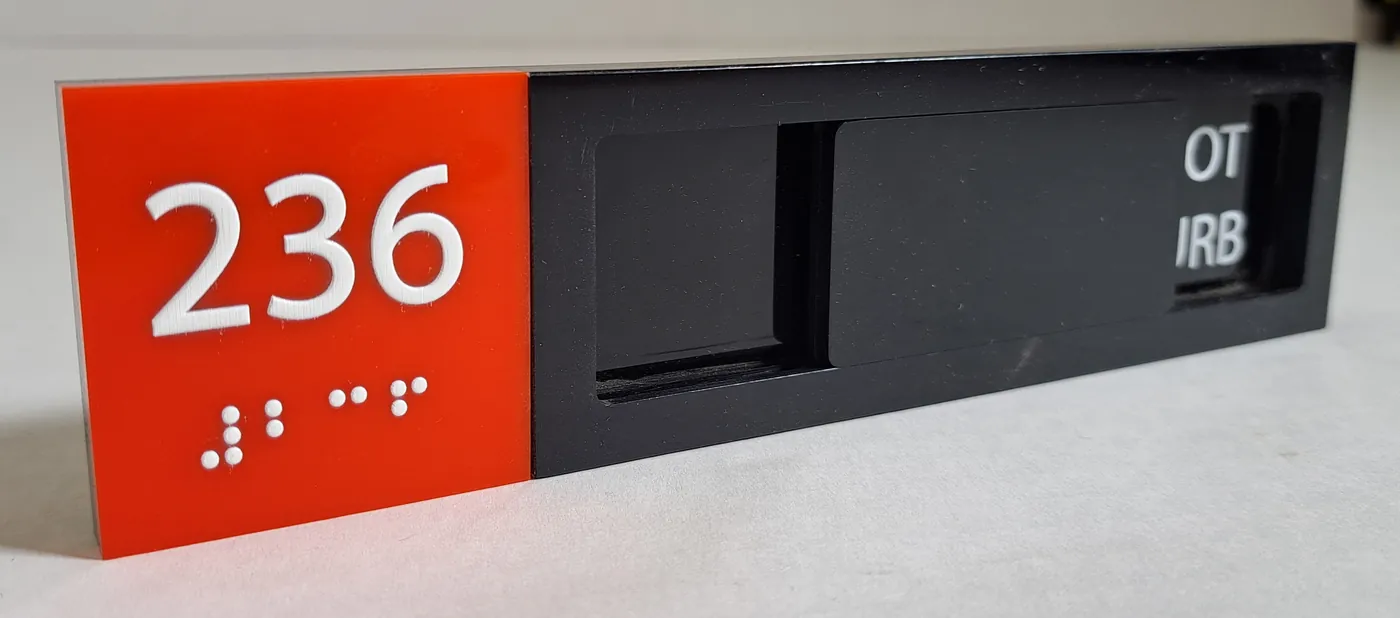 Red room sign 236 with raised tactile dots, beside a black panel with a sliding indicator