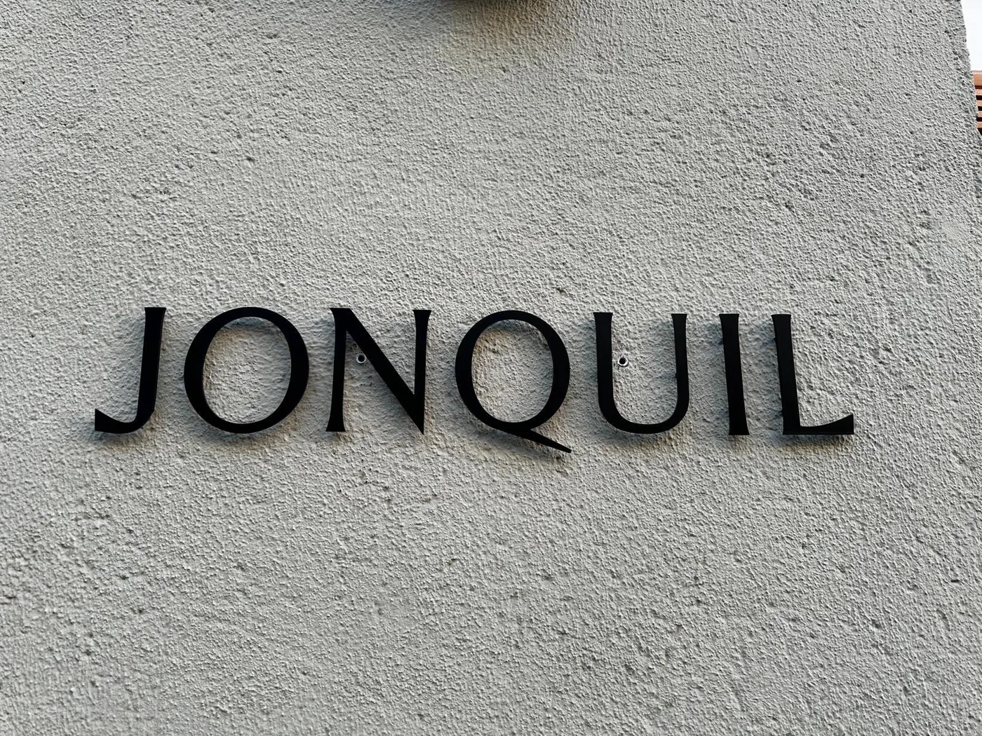 Black letters fixed to a textured rendered wall