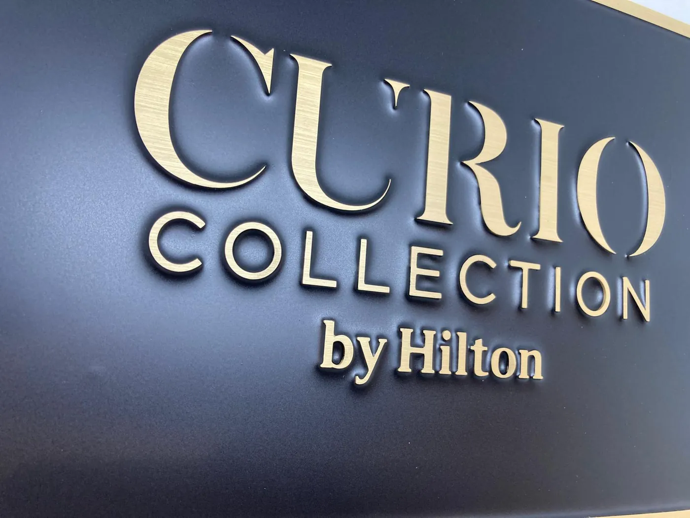 Close view of the raised gold-tone letters standing off the dark sign panel