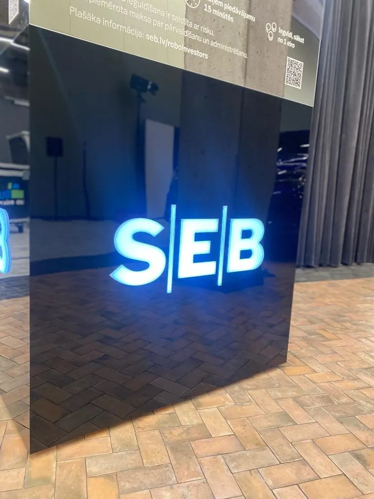 Black gloss pylon at an event with a logo lit in white and blue on its side
