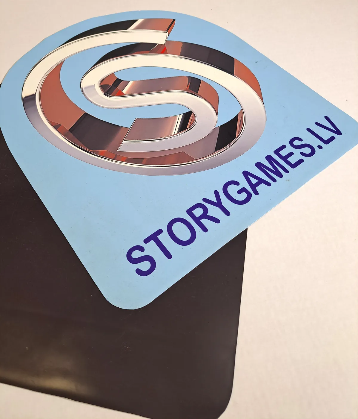 Pale blue sign with a mirror-finish logo and a web address