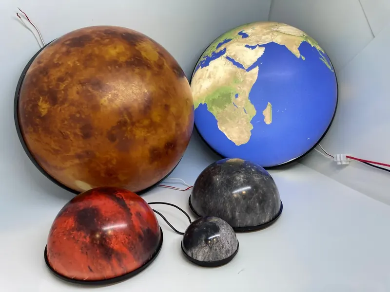Set of five planet models in different sizes, among them Venus, Earth and Mars, on their black ring bases
