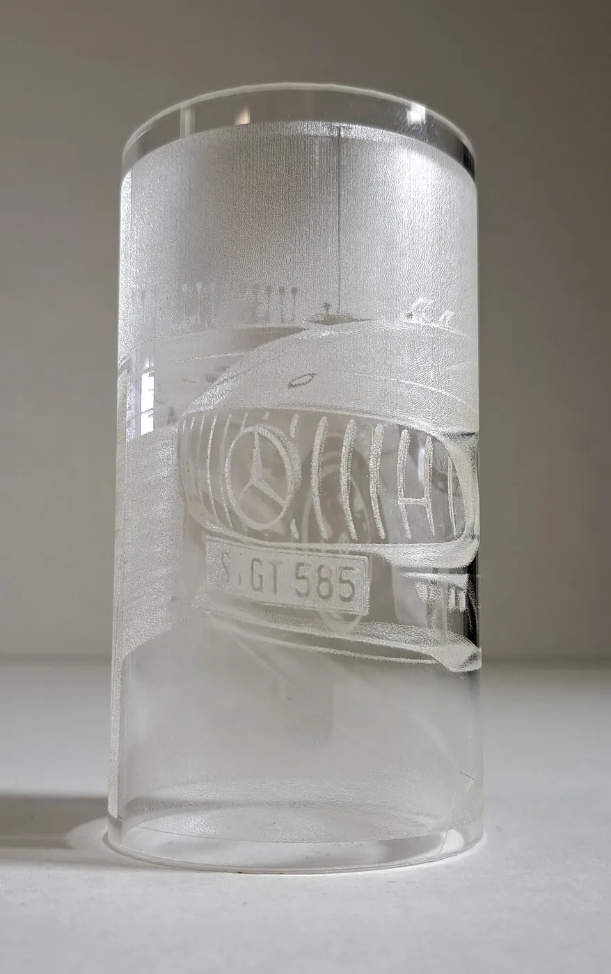 Clear cylinder engraved all the way round with a car and its number plate